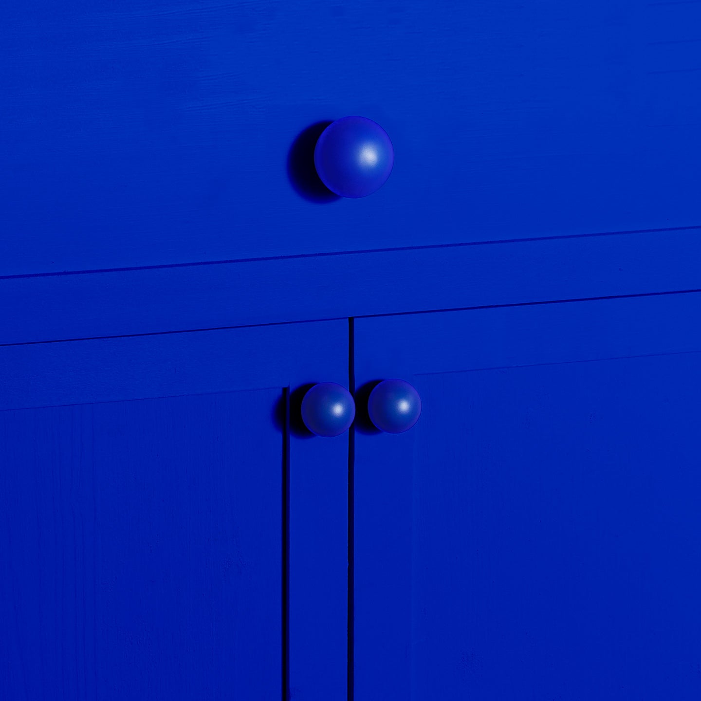 Large and small sphere knobs in klein blue on cabinet and drawer