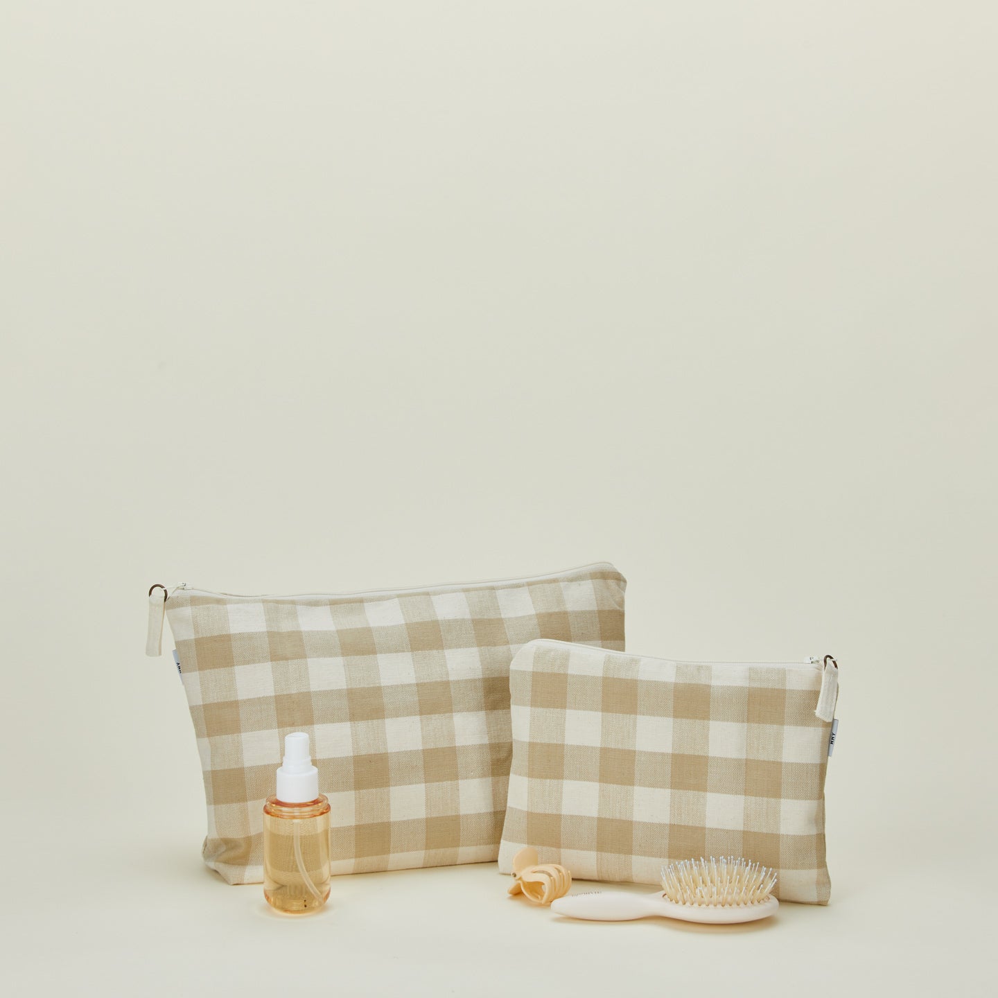 Essential gingham pouches in ivory and flax with hair care products