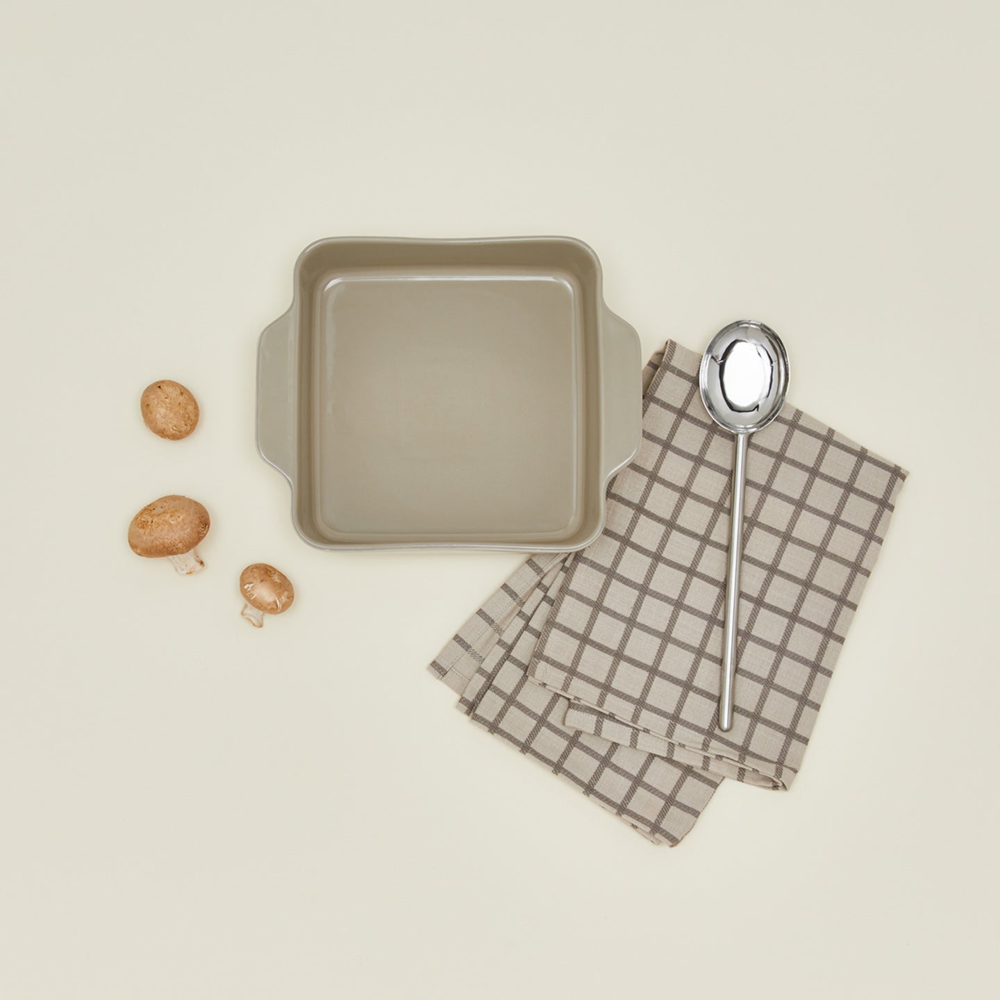 8" x 8" essential bakeware in light grey with mushrooms, spoon, and dish towel