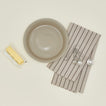 pie dish in light grey with butter, dish towel, and measuring spoons