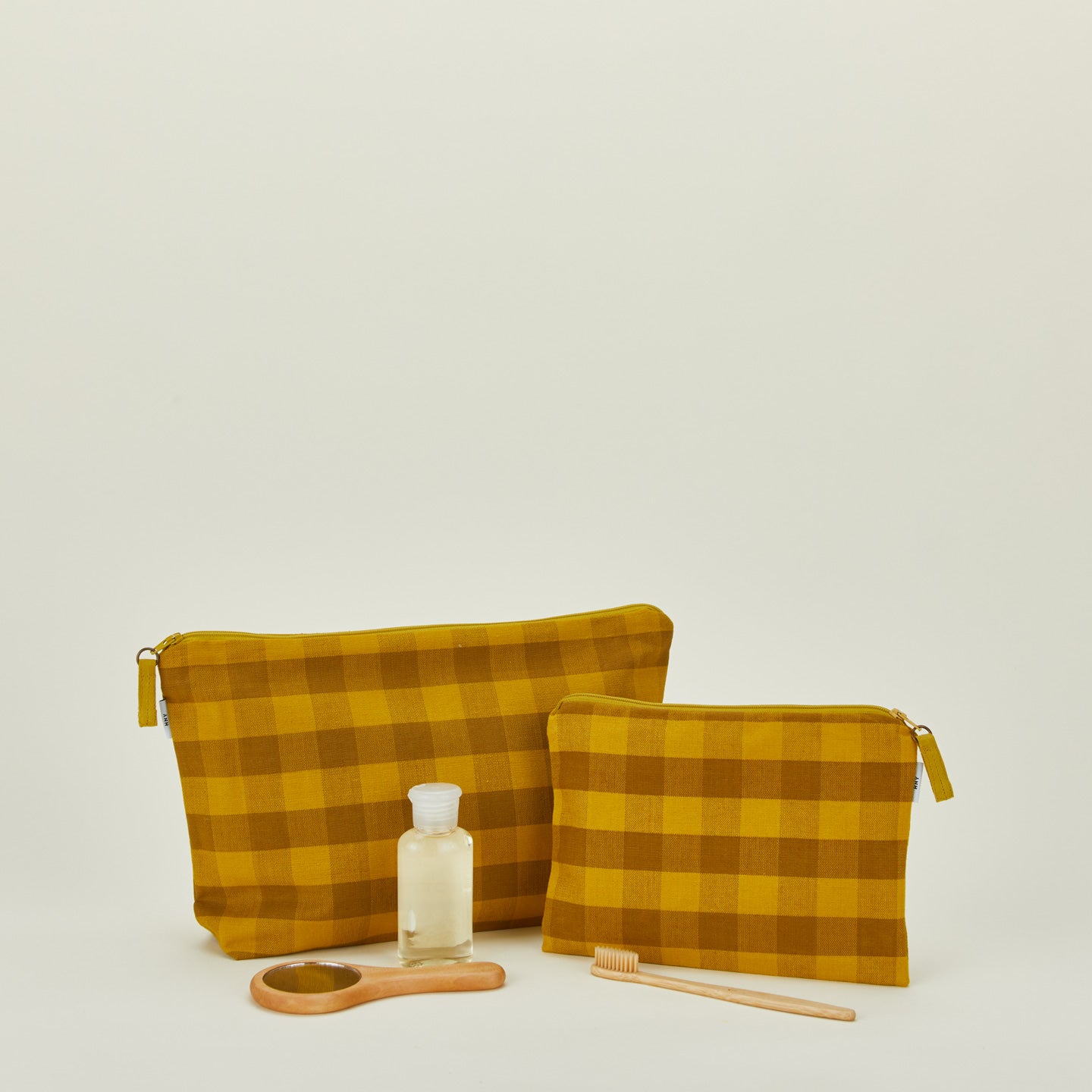 Essential gingham pouches in mustard and bronze with personal care products