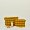 Essential gingham pouches in mustard and bronze with personal care products