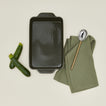 9" x 13" Essential bakeware in olive with cucumbers, spoon, and dishtowel