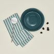 Pie dish with blackberries dishtowel and slotted spoon