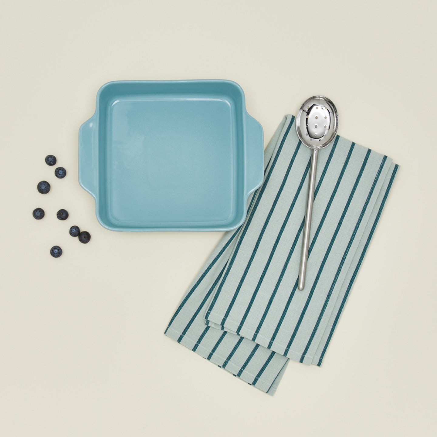 8x8 bakeware in sky with blueberries dishtowel and slotted spoon