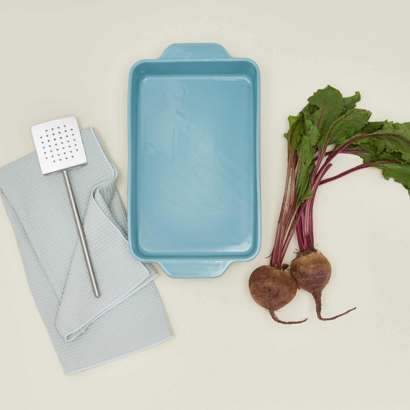 9" x 13" Essential bakeware in sky with beets, spatula, and dishtowel
