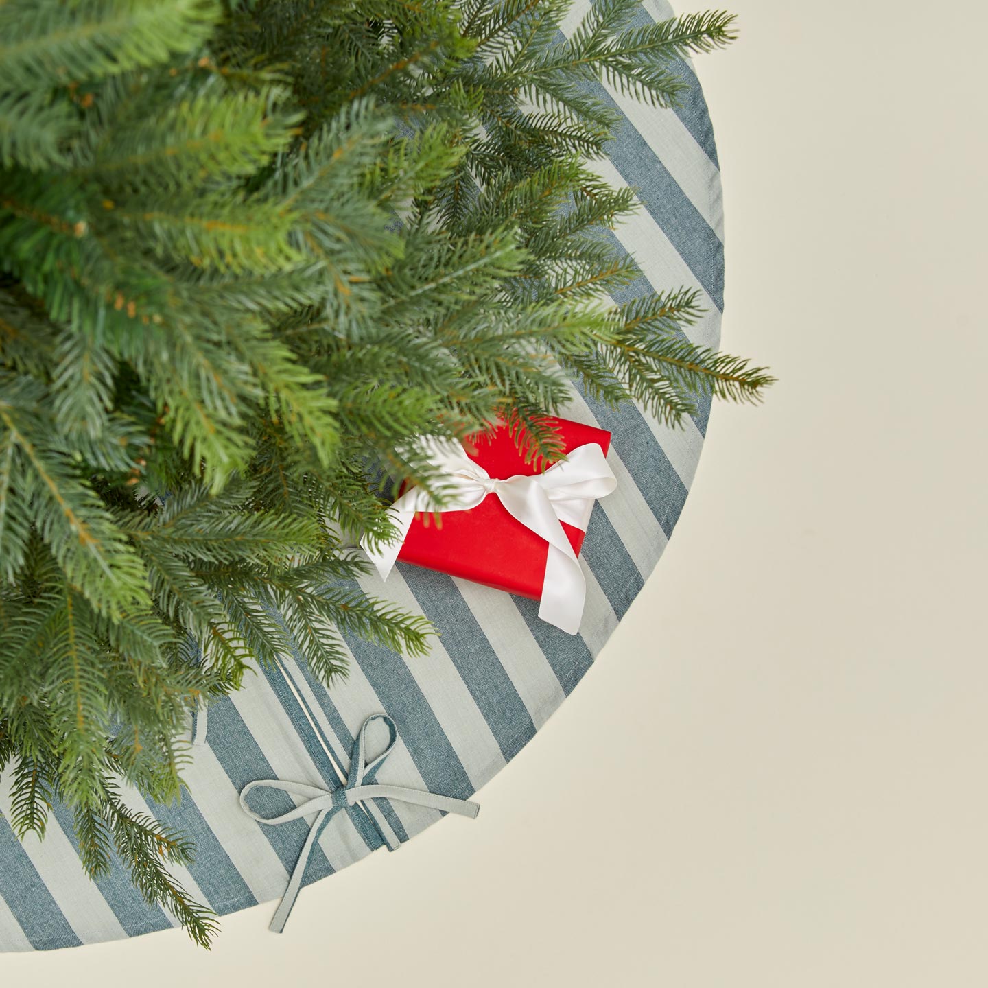 Overhead view of Essential Striped Tree Skirt - Sky/Peacock with tree