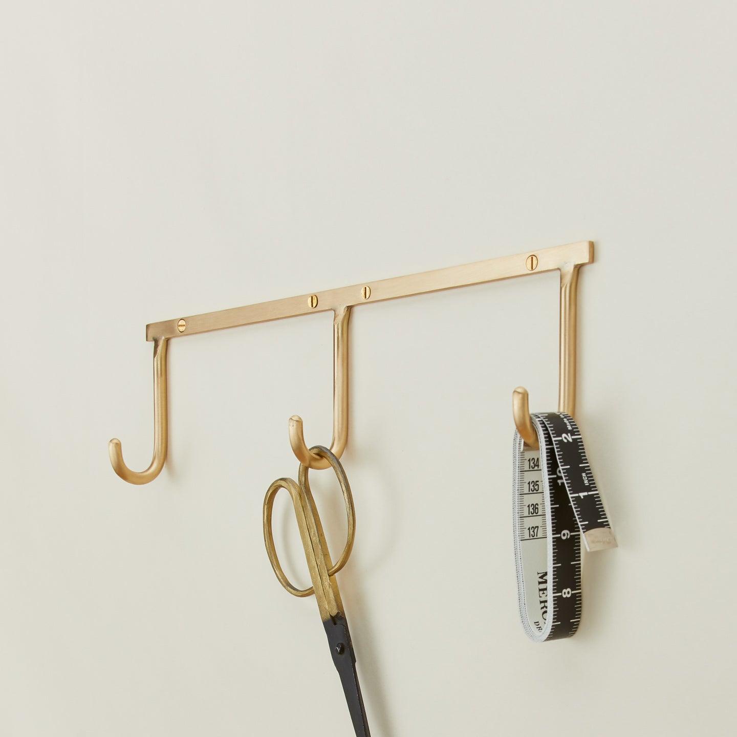 Brass hook rack trio with scissors and measuring tape