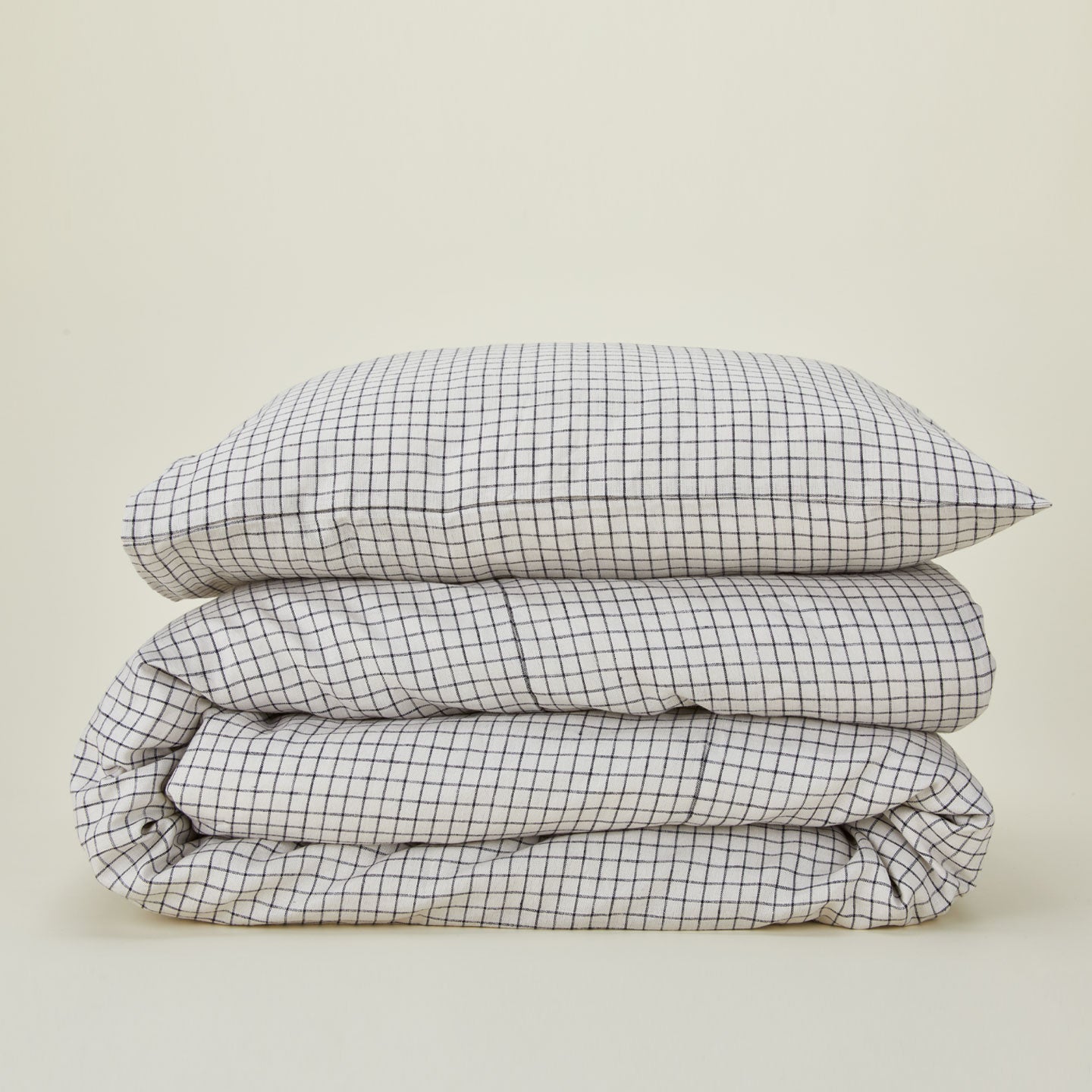 A folded checked linen duvet cover with a checked linen pillow case.