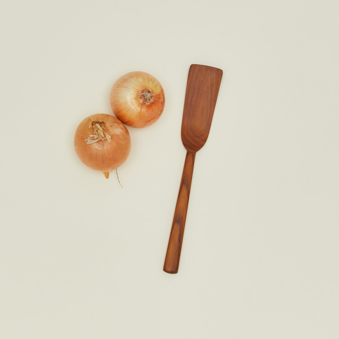 Narrow teak spatula with onions