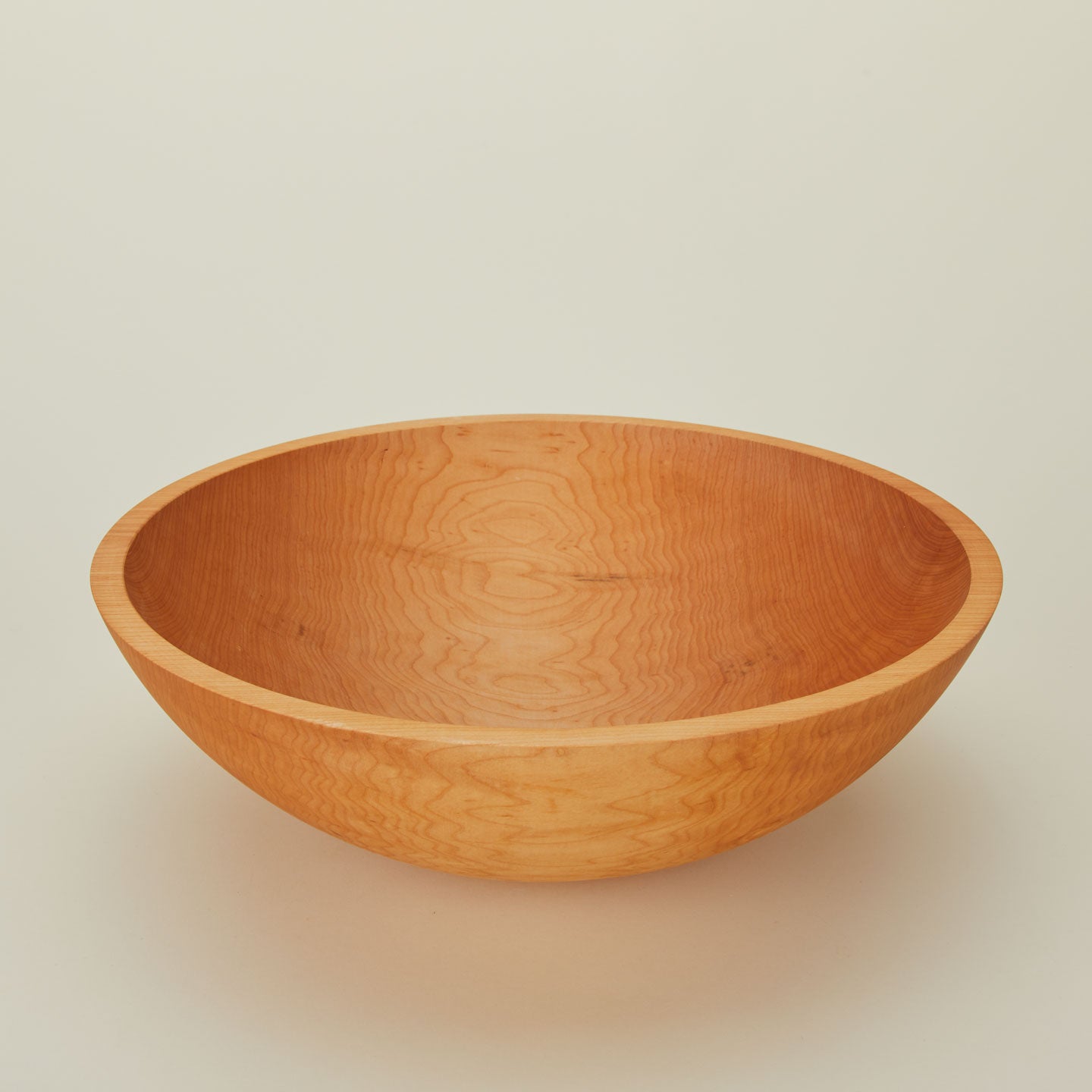 A close up  of a 17” maple wood bowl.