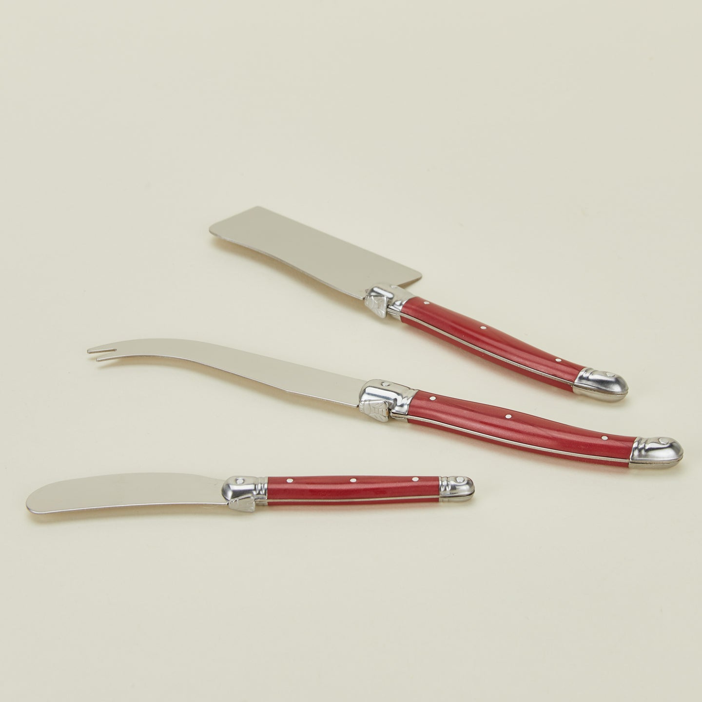 Close up view of Jean Dubost cheese knives in red