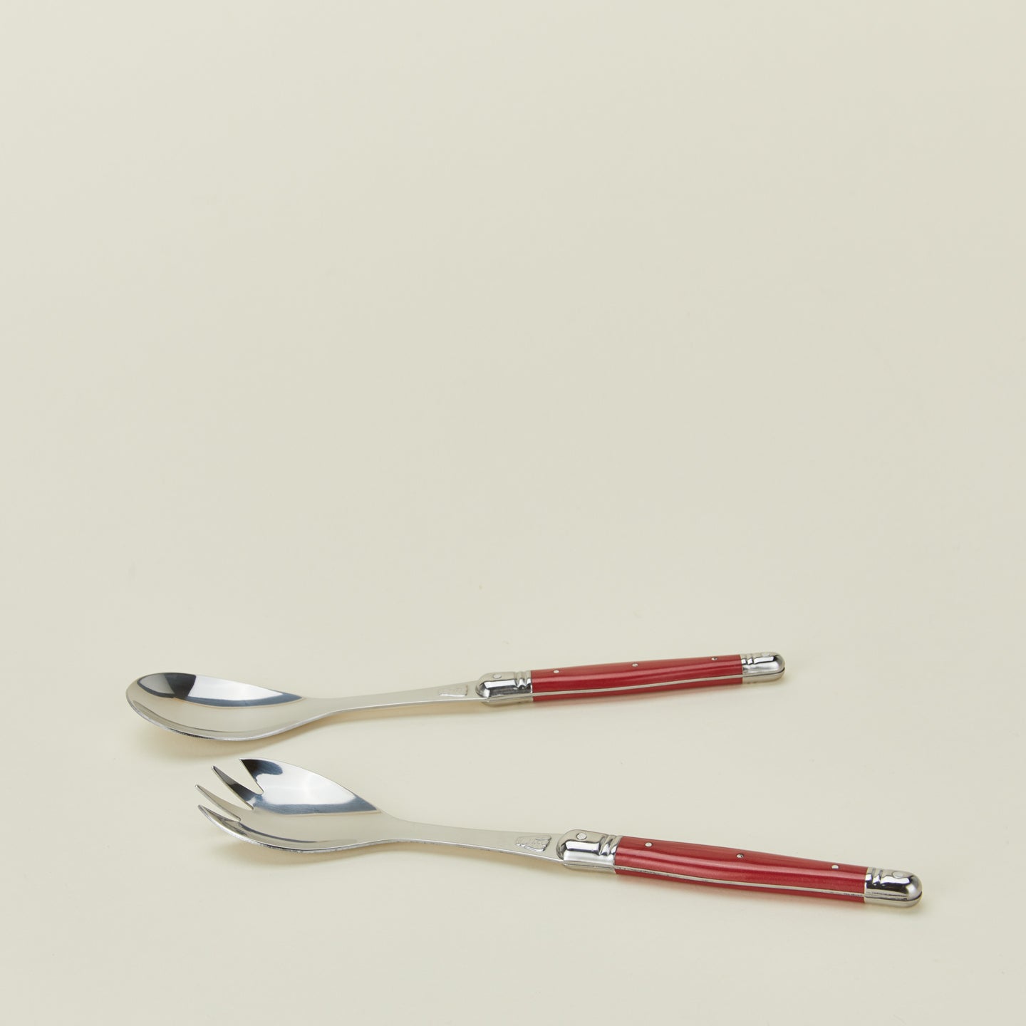 Close up view of Jean Dubost salad servers in red