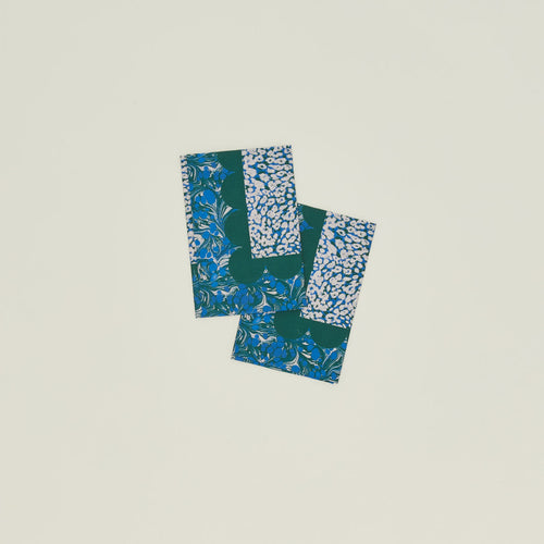 A set of two mixed floral napkins with an evergreen pattern.