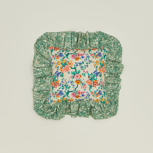 A ruffled floral cushion with a fern pattern.