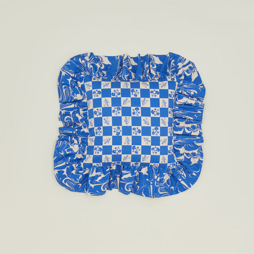 A ruffled floral cushion with a klein blue pattern.