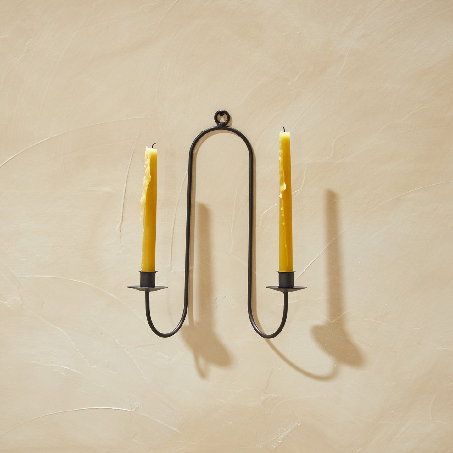 Double Iron Candle Sconce on a plaster wall with candles