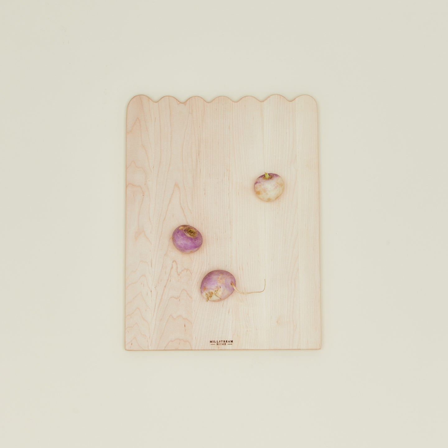 Overhead view of medium scalloped cutting board with radishes