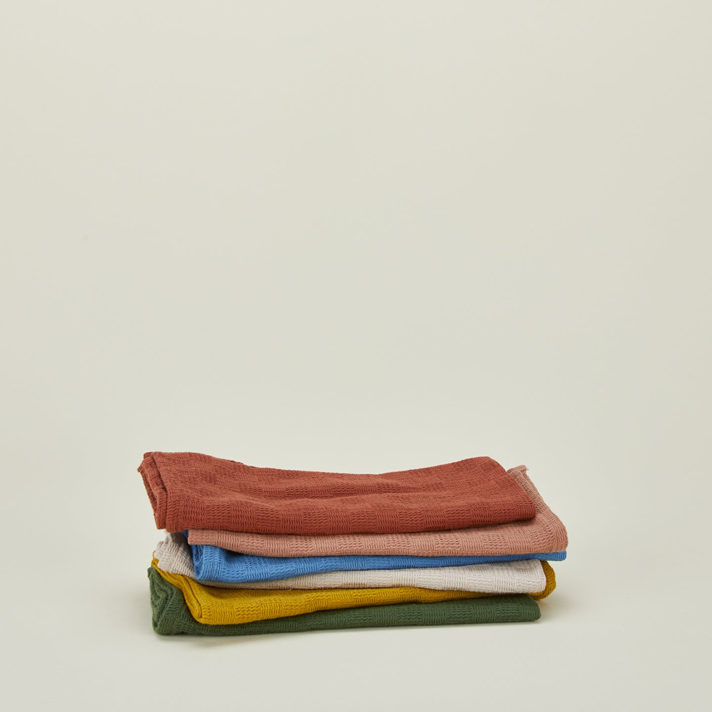 Stack of woven stripe kitchen towels in various colors