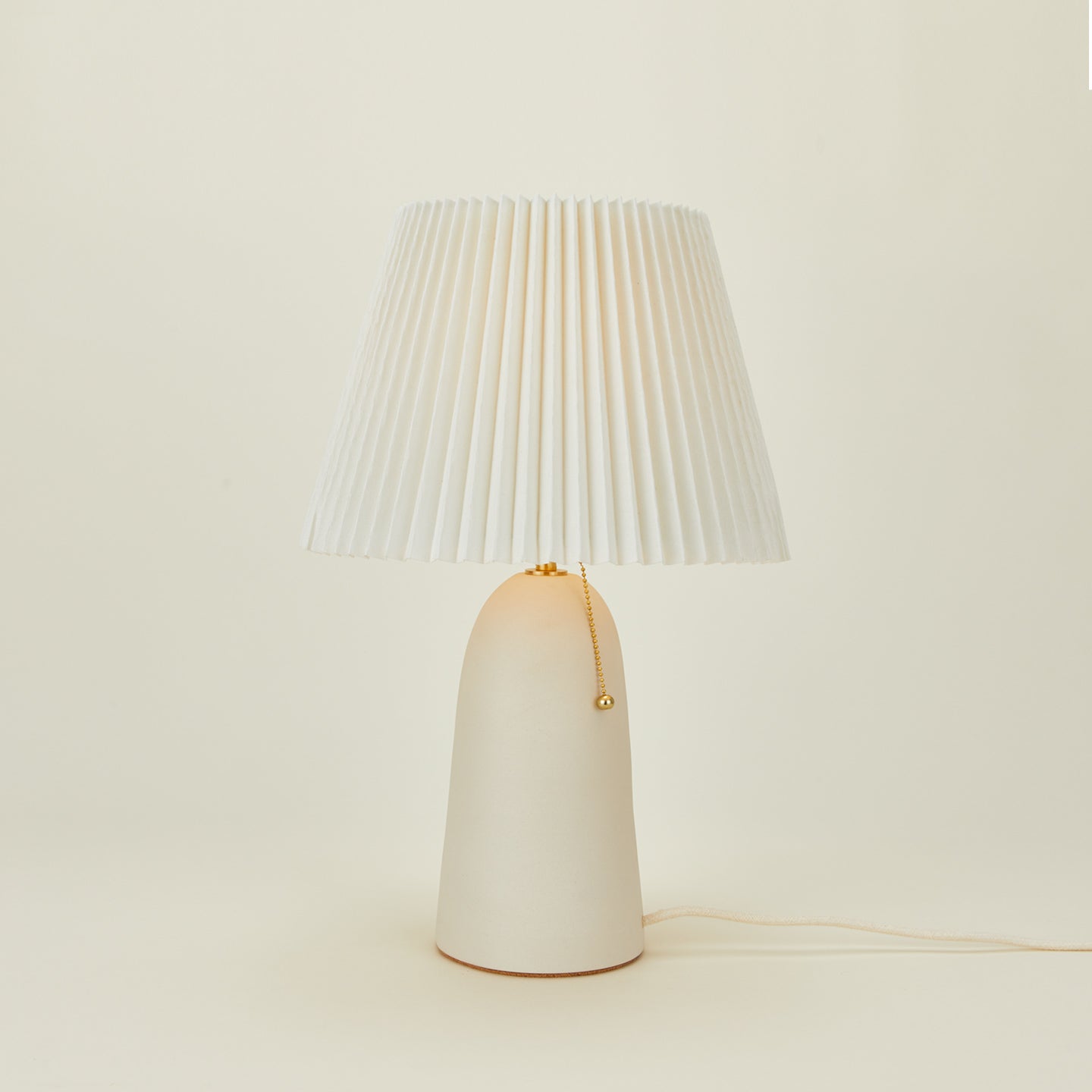 Pleat table lamp in bone with ivory shade