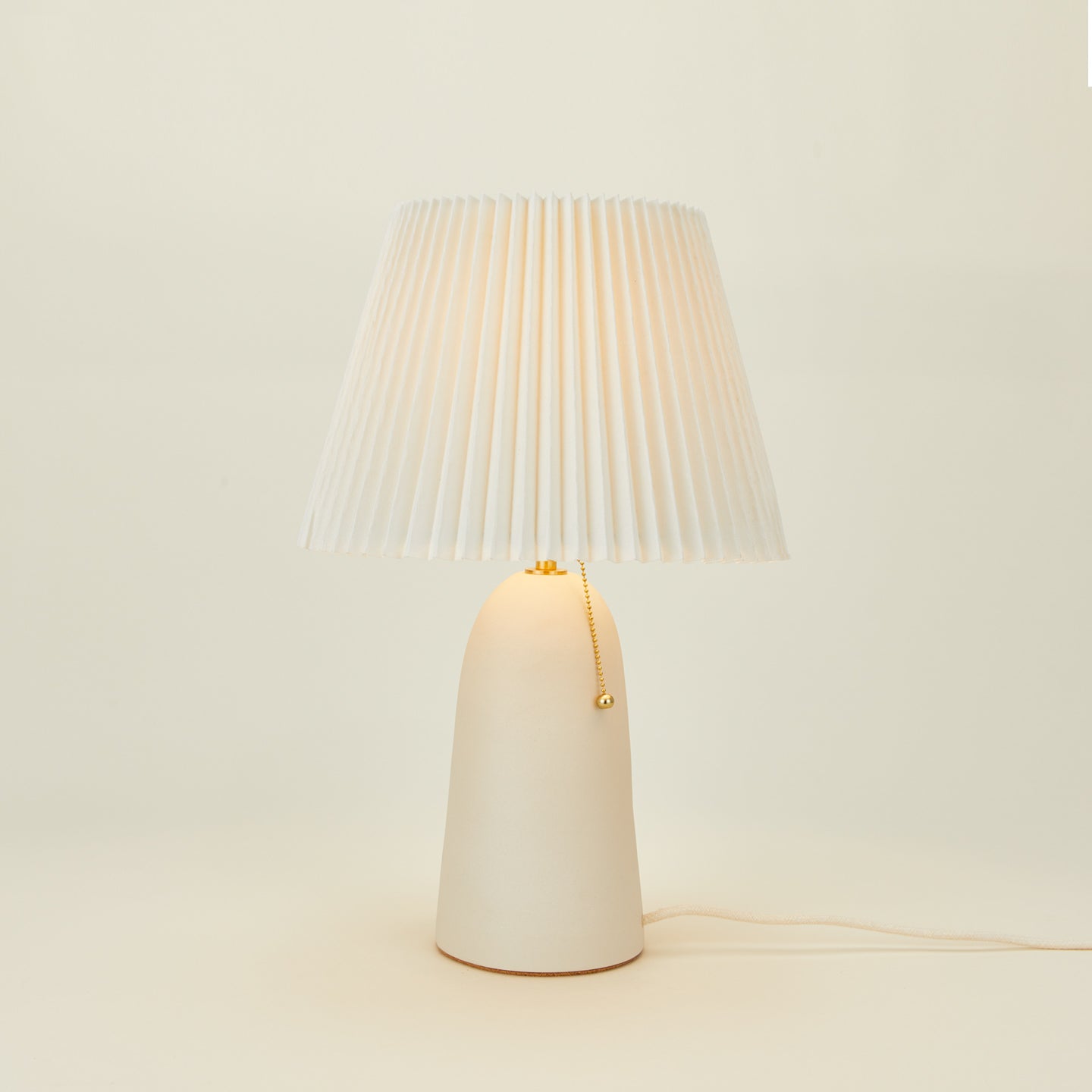 Pleat table lamp in bone with ivory shade
