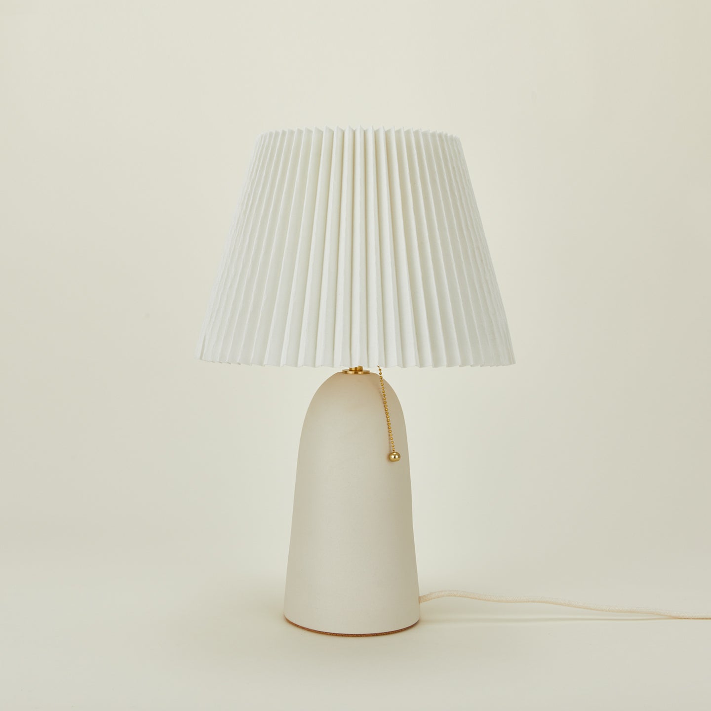 Pleat table lamp in bone with ivory shade