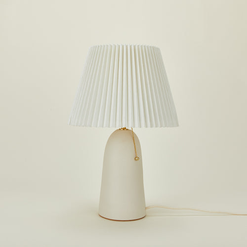 Pleat table lamp in bone with ivory shade