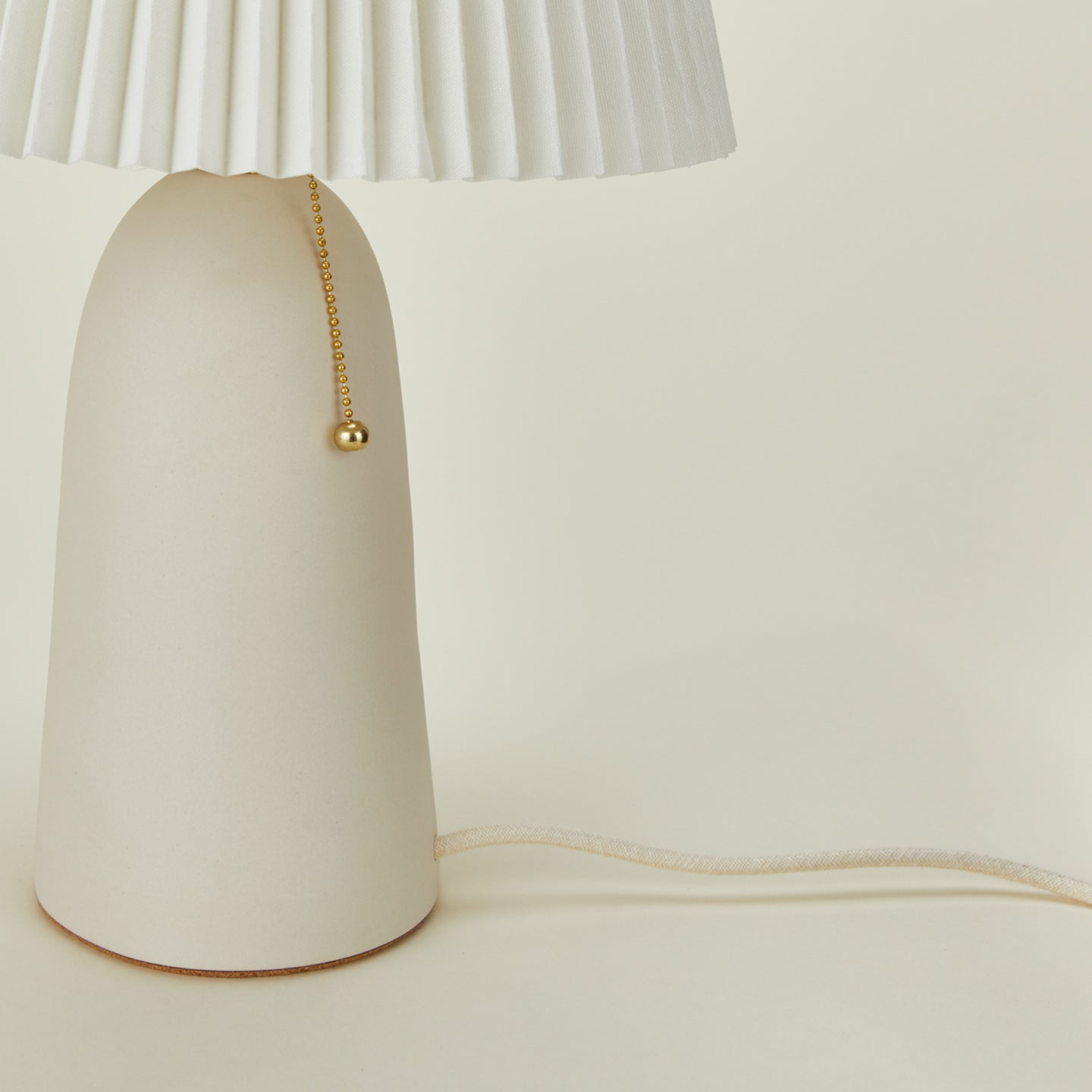 Close up view of Pleat table lamp in bone with ivory shade