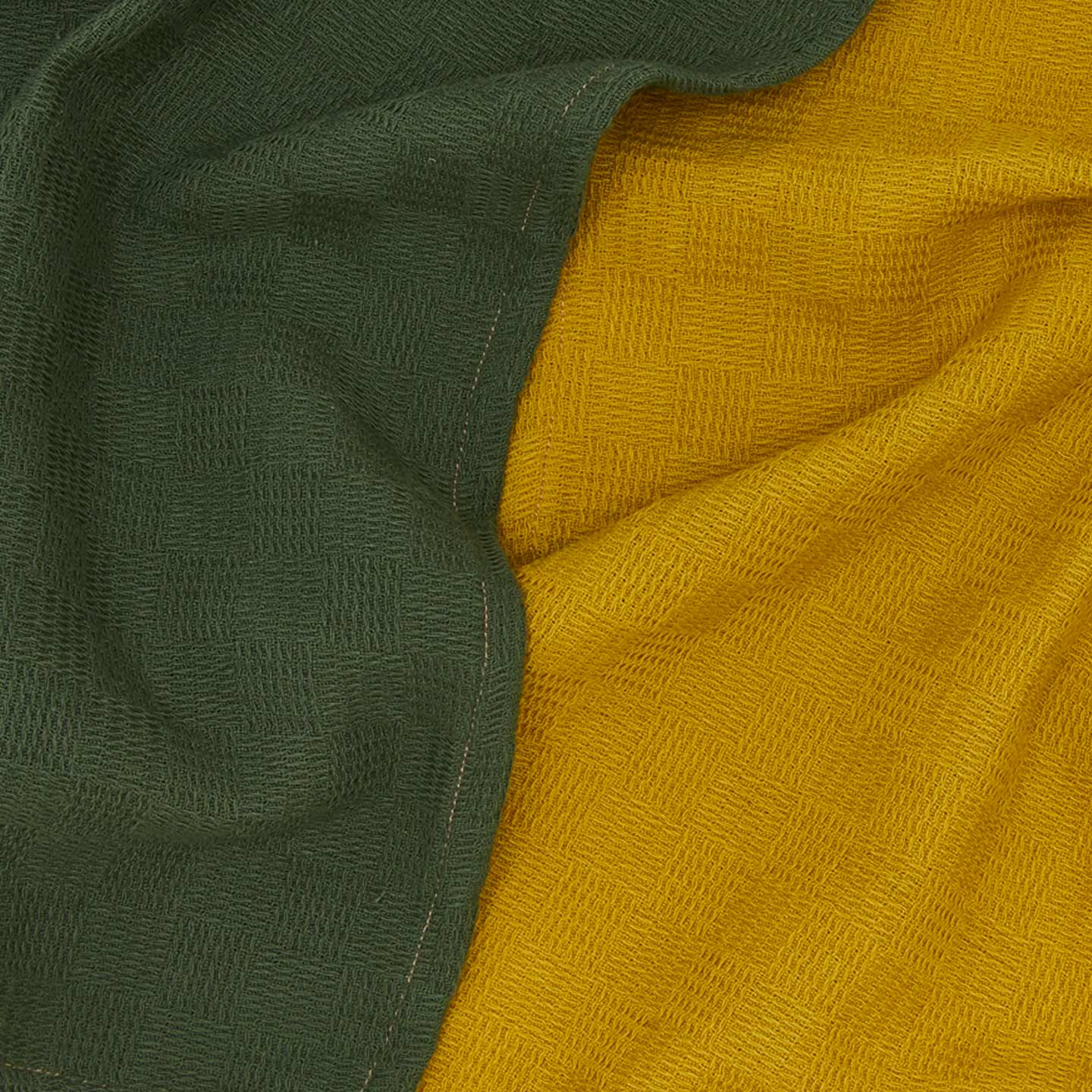 Close up view of woven stripe kitchen towels in mustard and olive