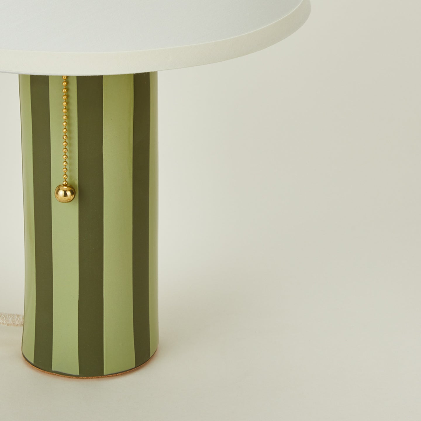 Close up view of Pillar table lamp with olive stripe