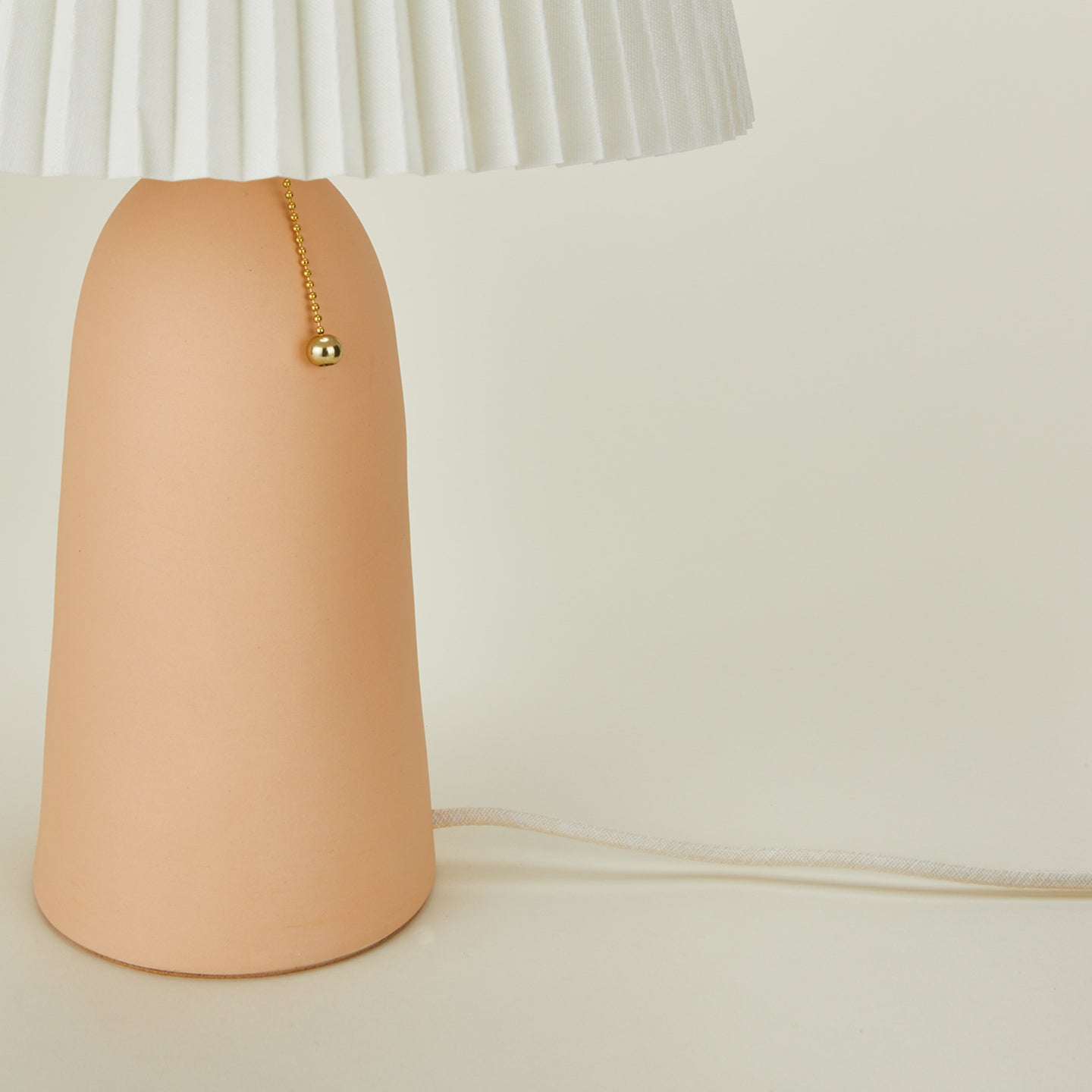 Close up view of Peach Pleat Table Lamp with Ivory Shade