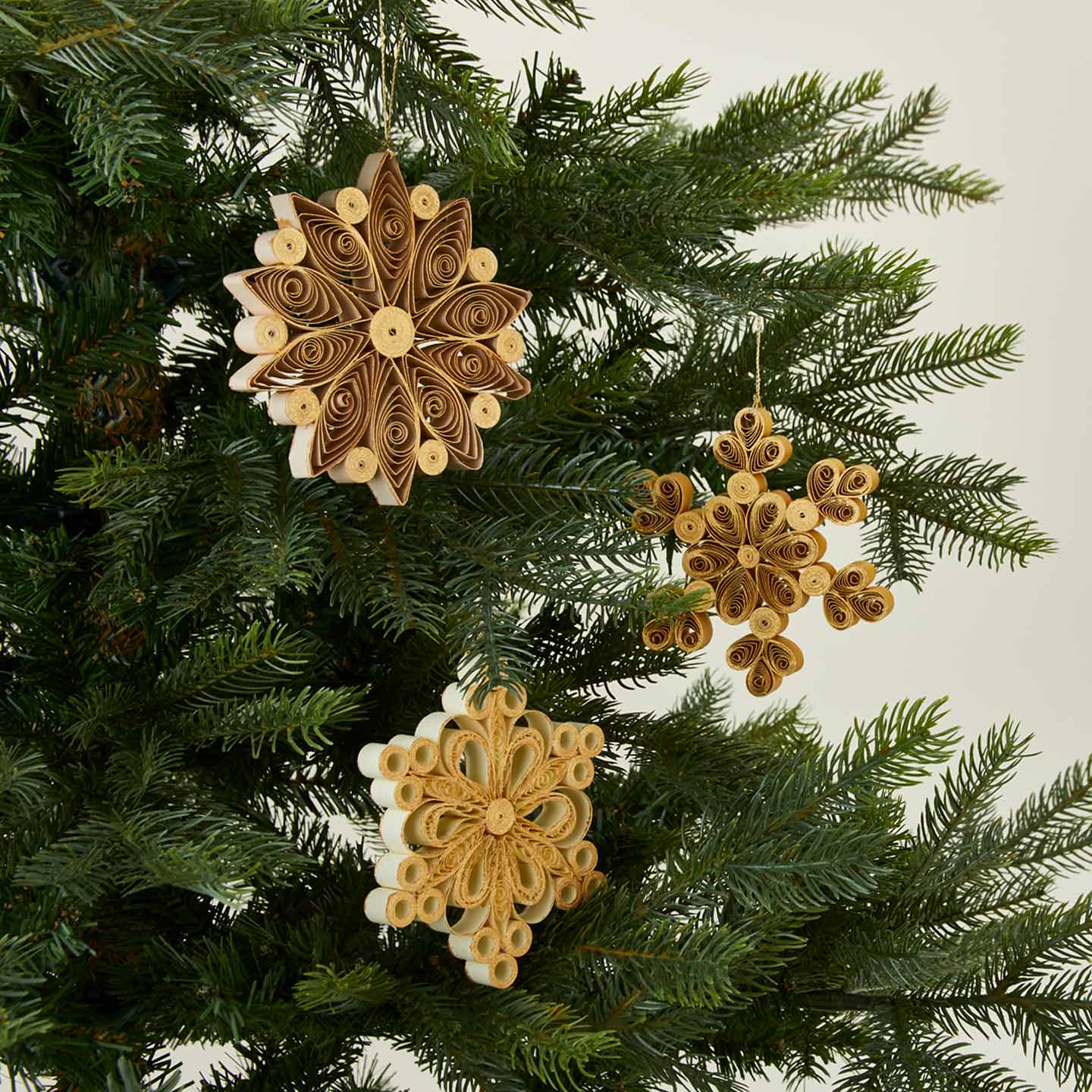 Quilled snowflake ornaments in neutral on tree