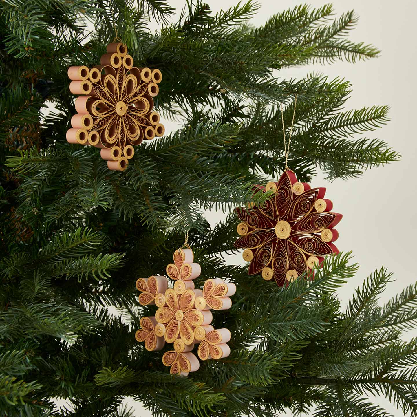 Quilled snowflake ornaments in warm on tree
