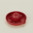 Three-quarter angle of stoneware citrus juicer in Coral.