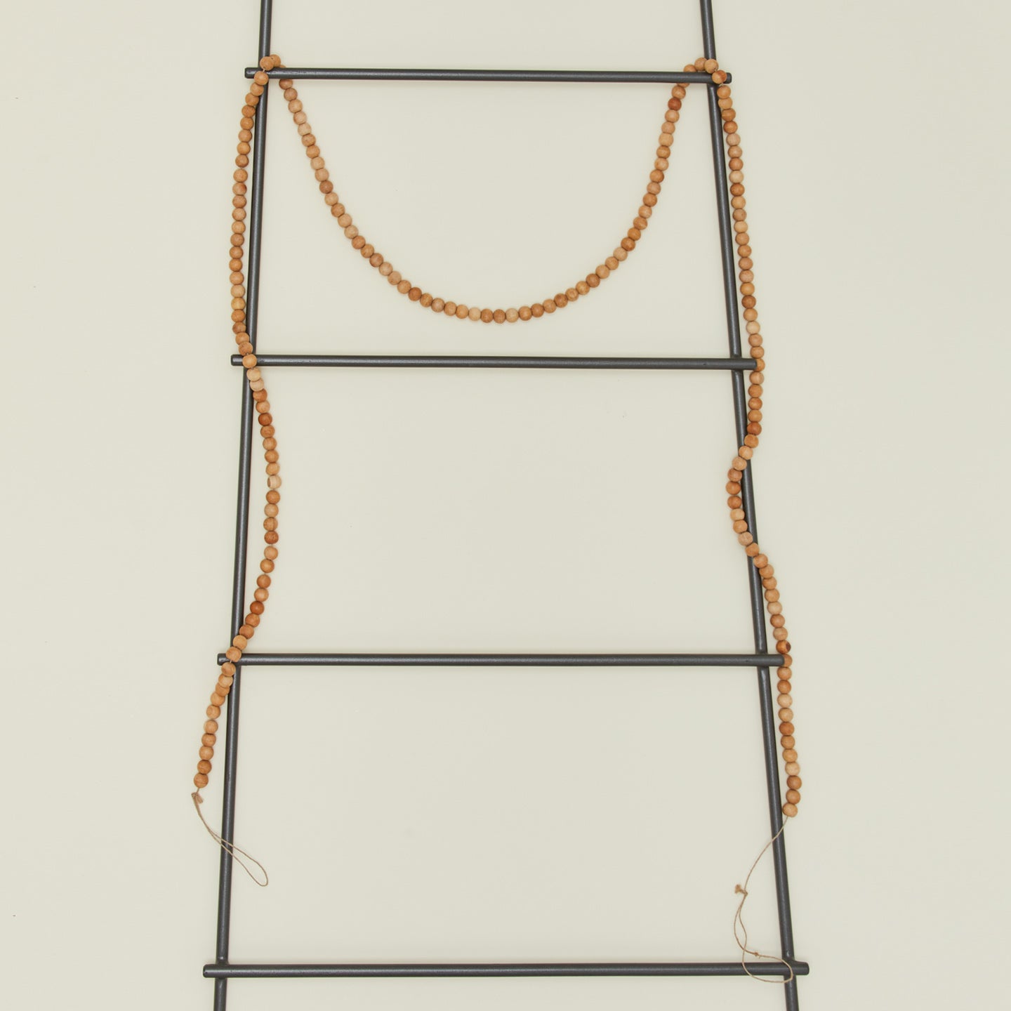 Natural wood beaded garland on ladder