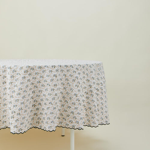 Little flowers round tablecloth in green on table.