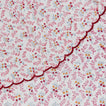 Close up view of little flowers round tablecloth in maroon.