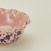 Close up view of Splatter scallop bowl in pink and blue
