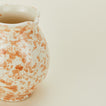 Close up view of Splatter cigno jug in tan and ivory