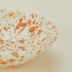 Close up view of Splatter low bowl in tan and ivory