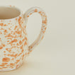 Close up view of Splatter mug in tan and ivory