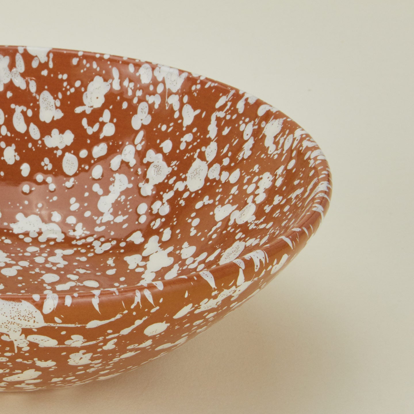 Close up view of Splatter low bowl in terracotta and ivory