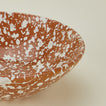 Close up view of Splatter low bowl in terracotta and ivory