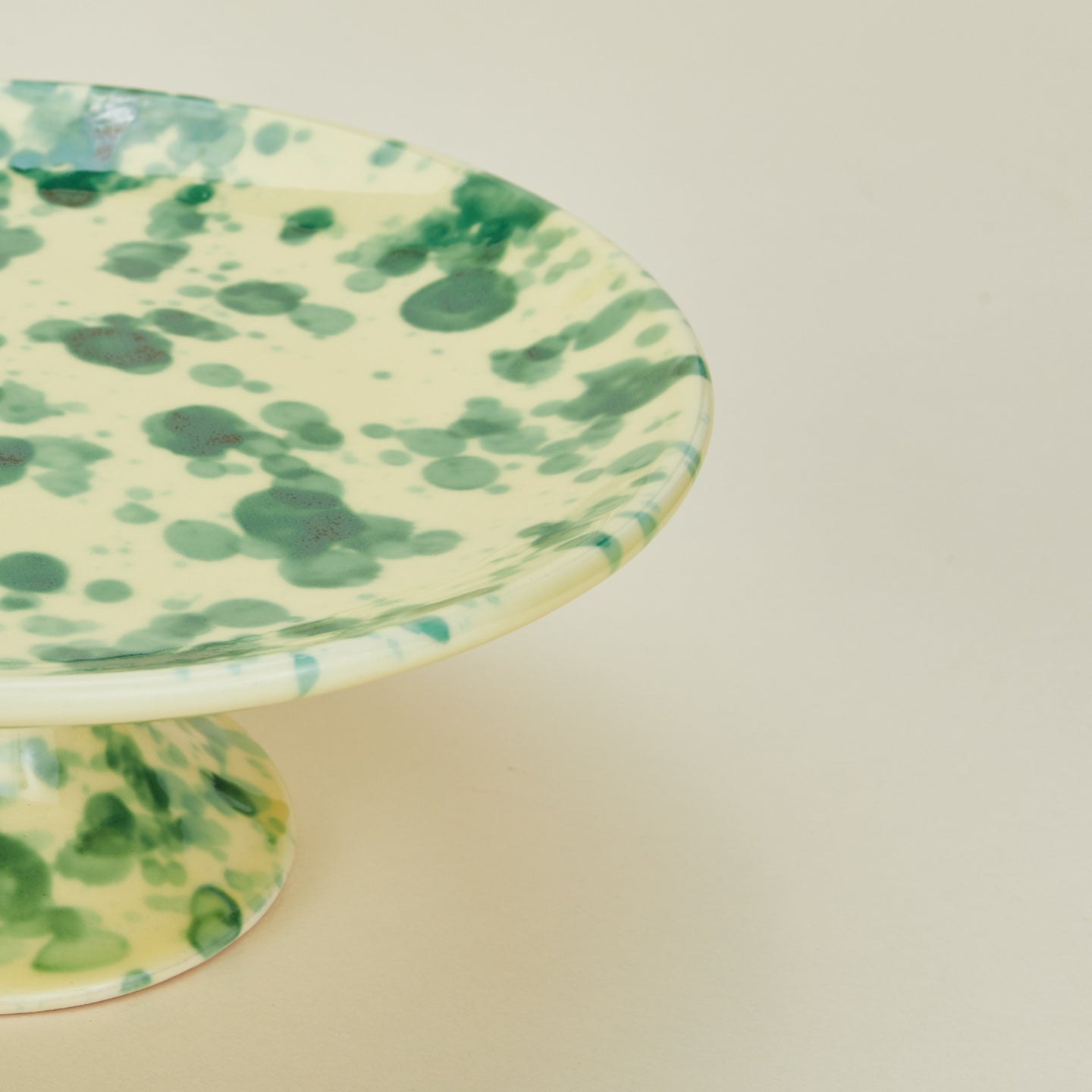 Close up view of Splatter cake stand in yellow and green