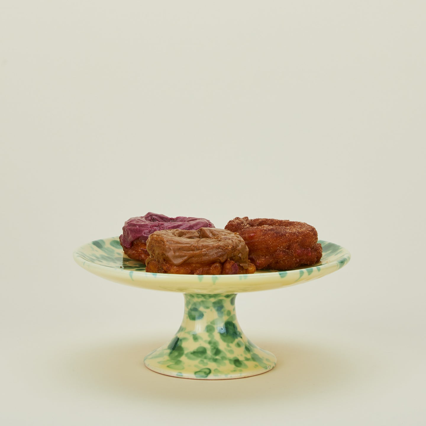 Splatter cake stand in yellow and green with donuts
