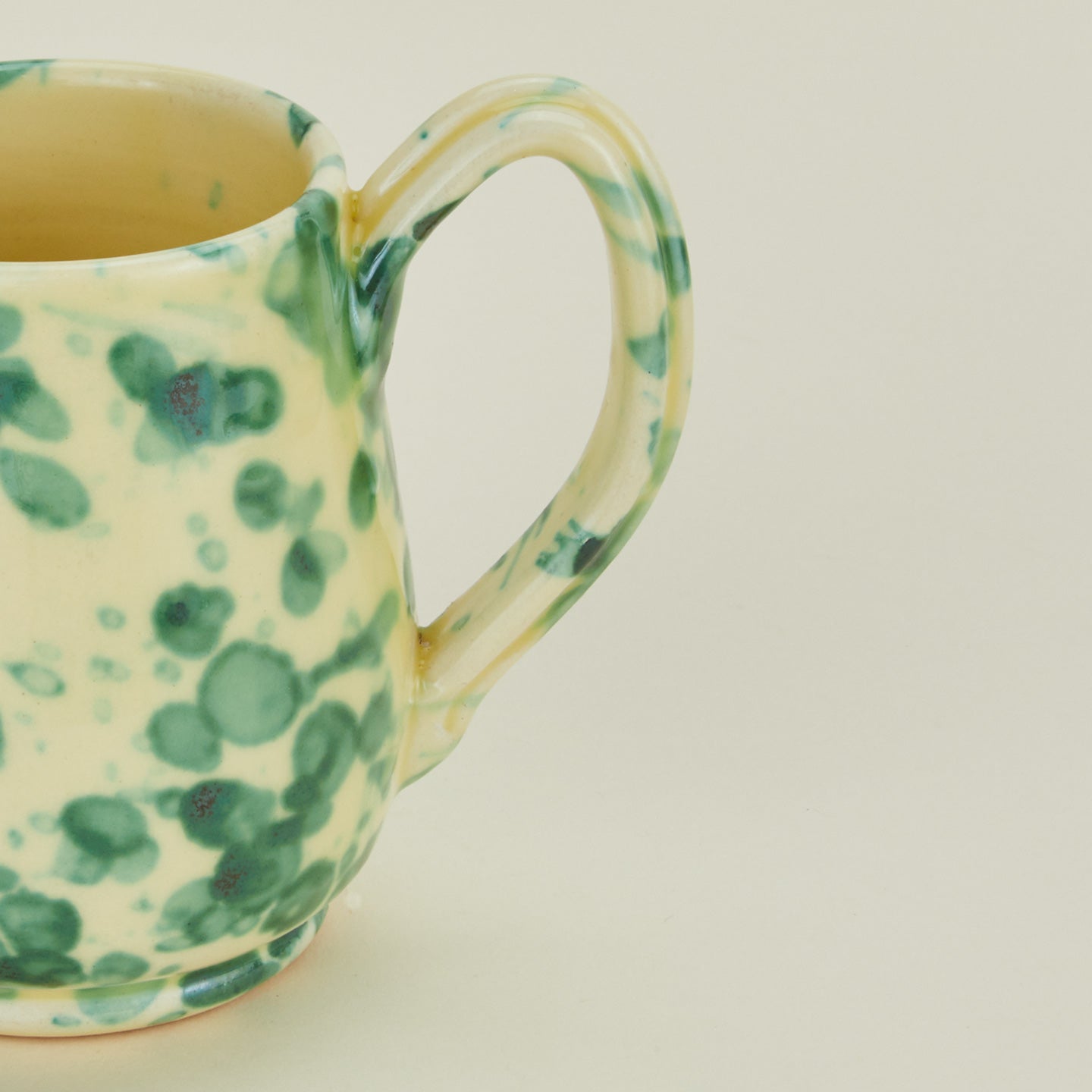 Close up view of Splatter mug in yellow and green