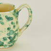 Close up view of Splatter mug in yellow and green