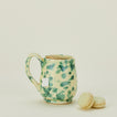 Splatter mug in yellow and green with macarons and tea