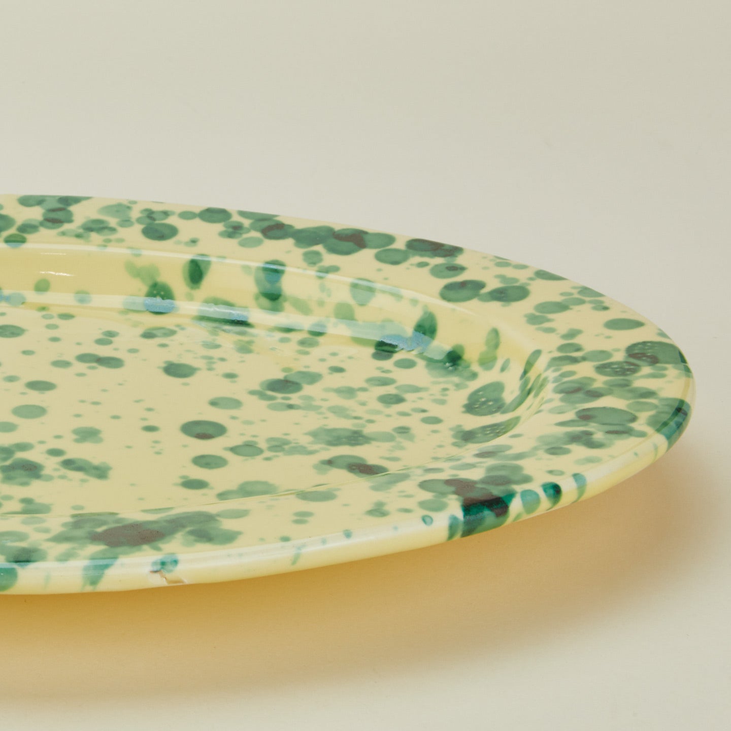 Close up view of Splatter yellow and green oval platter 