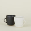 Two Stoneware Mugs, one in Black and one in Eggshell.